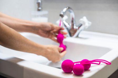 Image of a person washing sex toys in bathroom sink