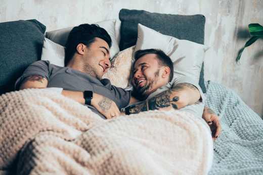 Image of two men laying in bed
