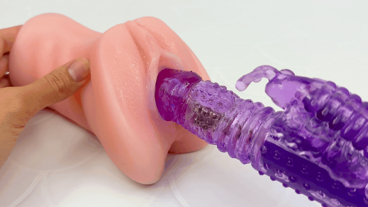 GIF of dual-action vibe thrusting in the entry of a model of a vagina