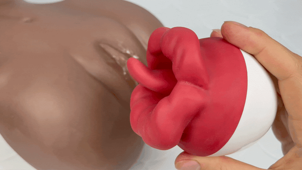 Flaming Red Lips Self-Motion Flickering Tongue Clit Stimulator in action being held above brown realistic male masturbator