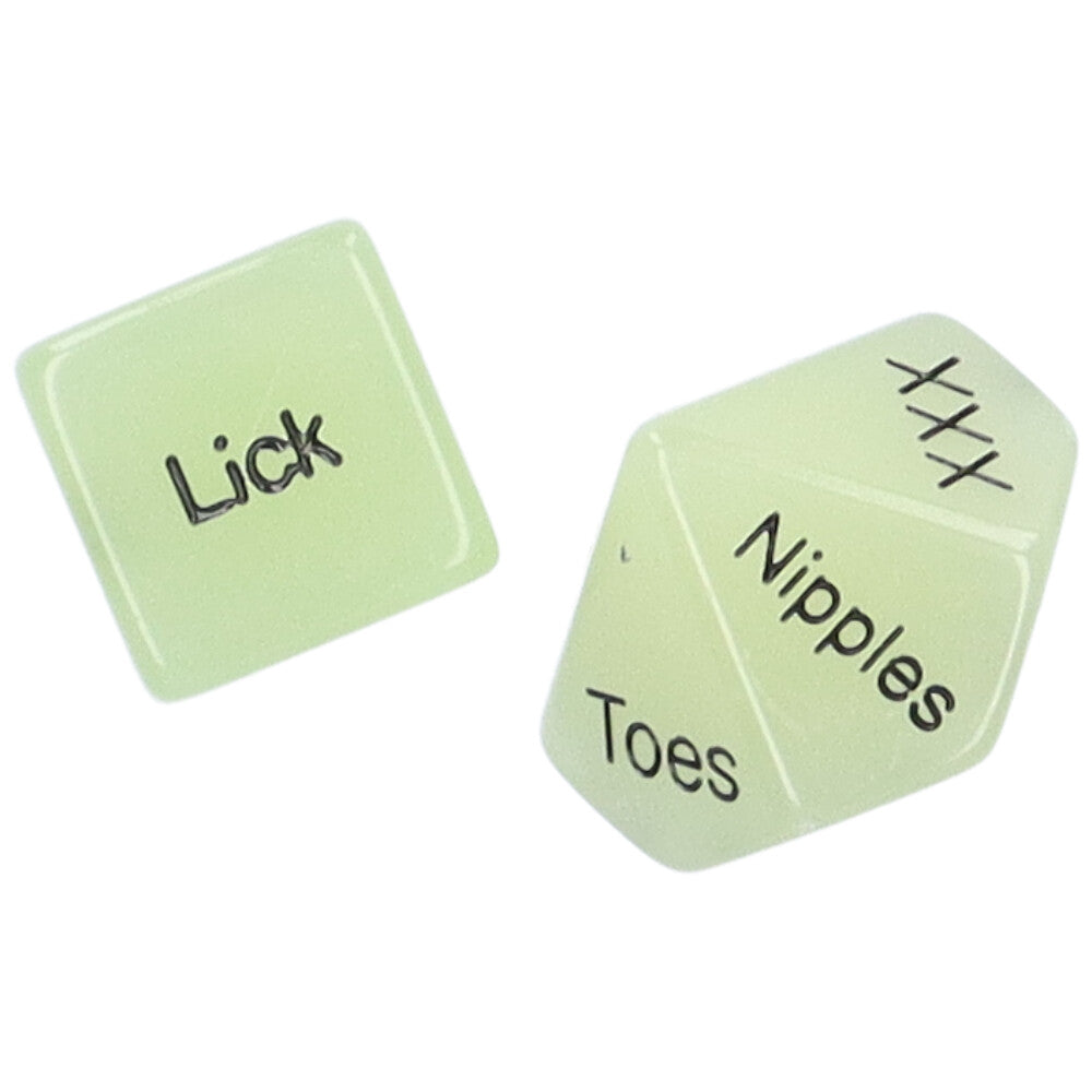 Bird's eye view of a pair of glow-in-the-dark sex dice showing the words "Lick" and "Nipples"