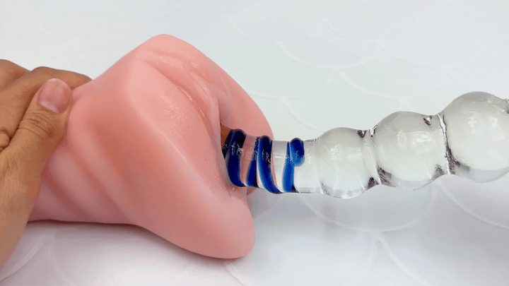 GIF of glass dildo thrusting in and out of a vagina - side view