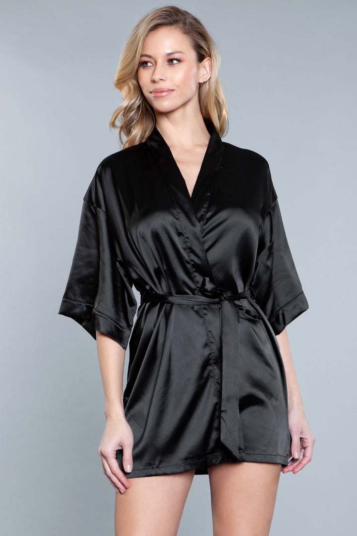 Model facing forward wearing black satin robe with side pockets. 3/4 sleeves and satin sash front tie