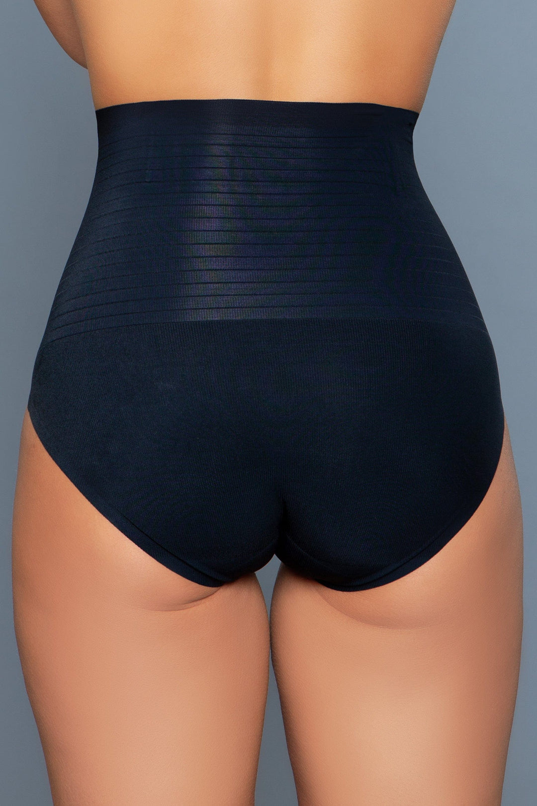 Model wearing seamless high-waisted tummy control body shaper with waist boning in black facing back close up