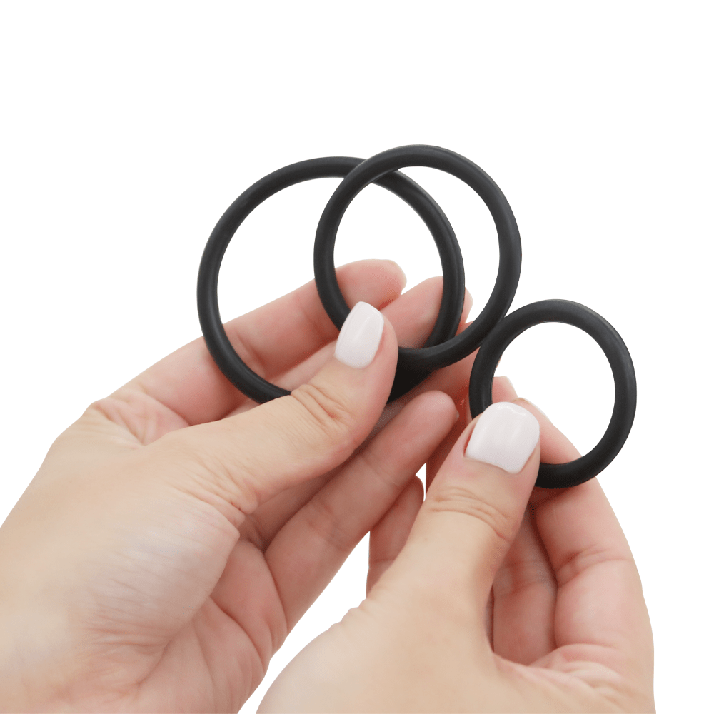 Image of hands holding the three cock rings.