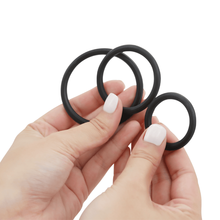 Image of hands holding the three cock rings.