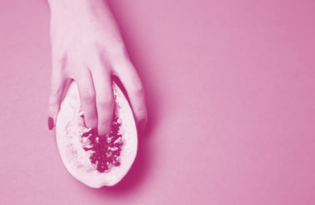 woman hand erotically touching open papaya 
