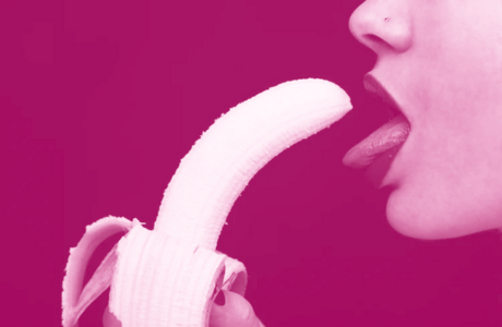 woman with tongue out erotically eating a banana