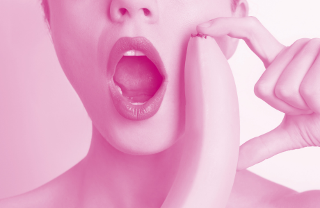 woman with mouth agape with banana next to her mouth 