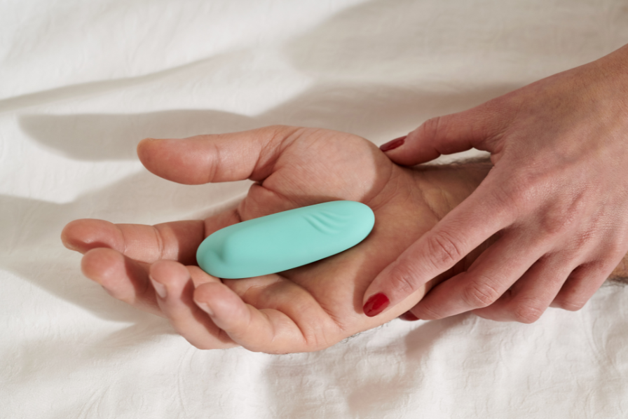 Couple holding hands with a wearable vibrator