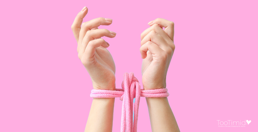 Pink shibari rope around person's wrists