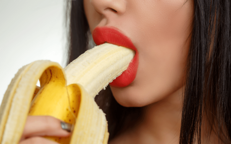 woman with mouth around banana