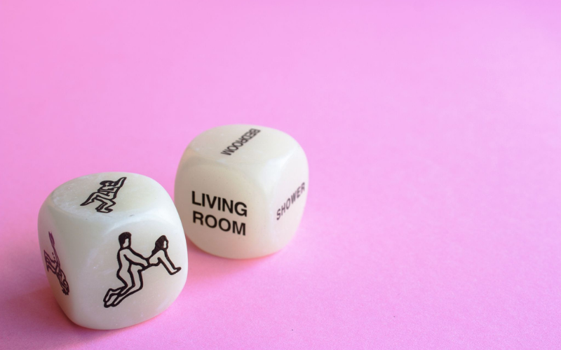 Sex dice featuring sex positions with pink background