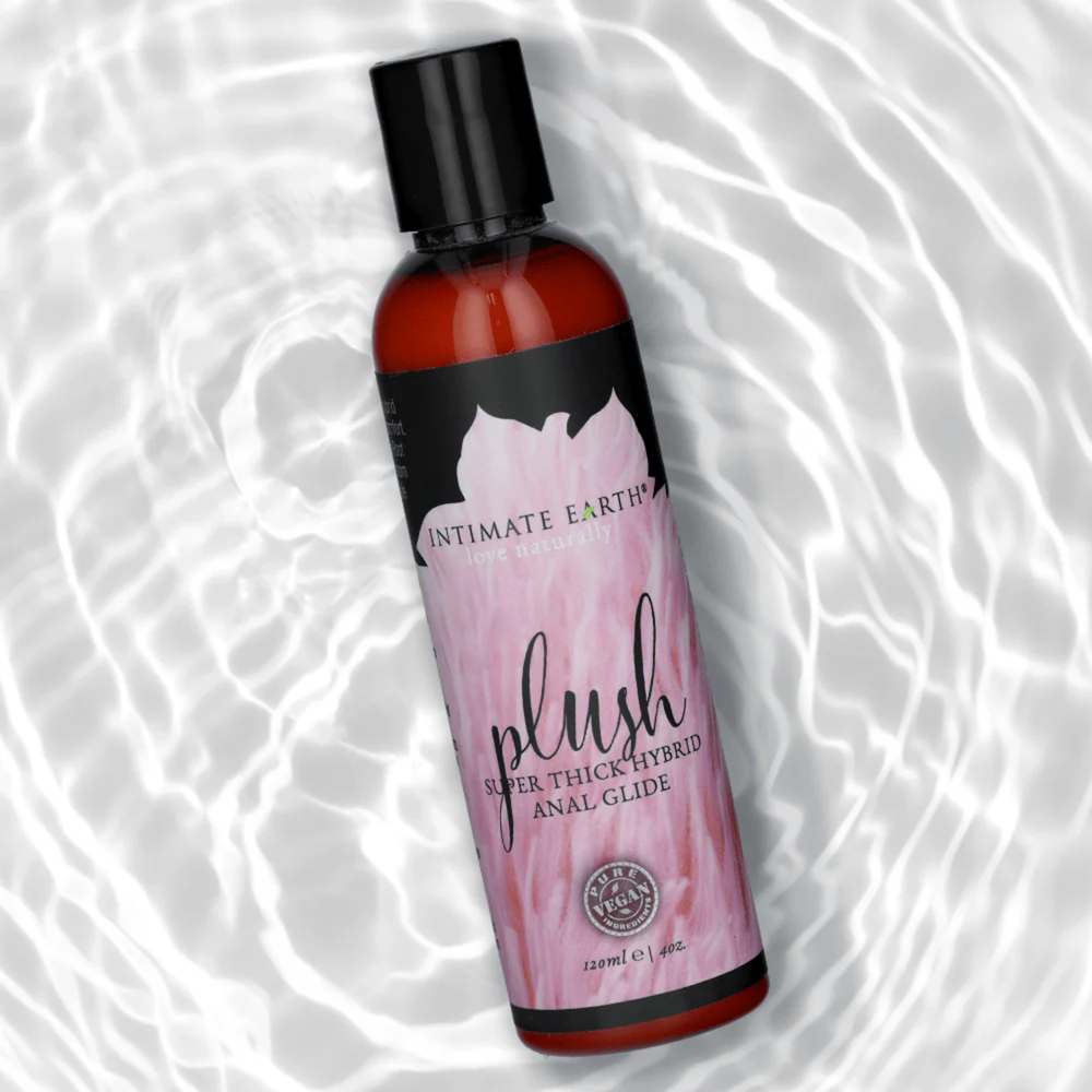 Intimate Earth Plush Hybrid Anal Glide Lubricant with water in background 