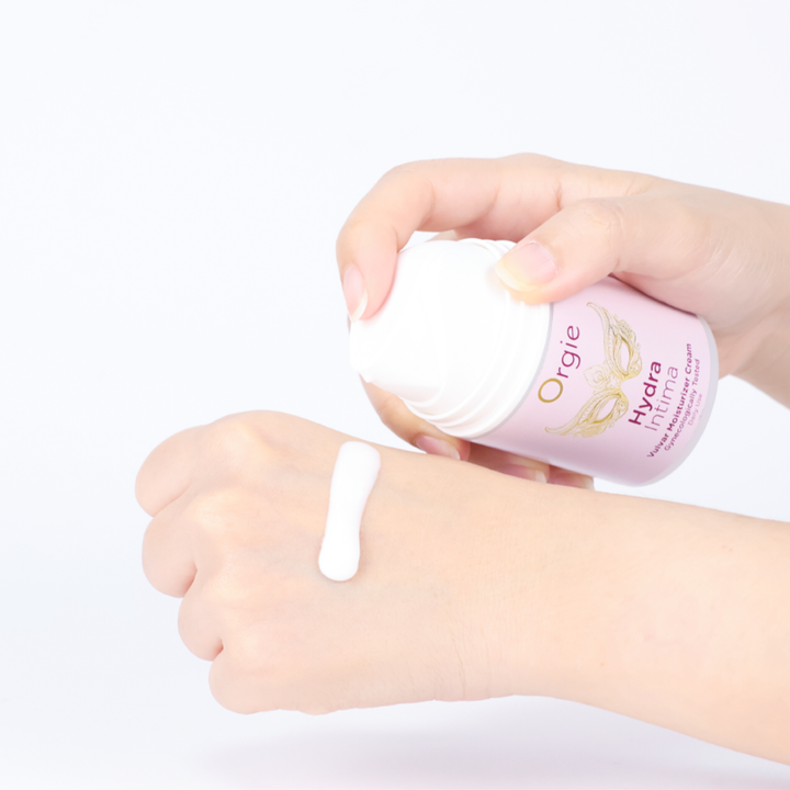 hand pumping Orgie Hydra Intimate Vulvar Moisturizer Cream onto back of hand 