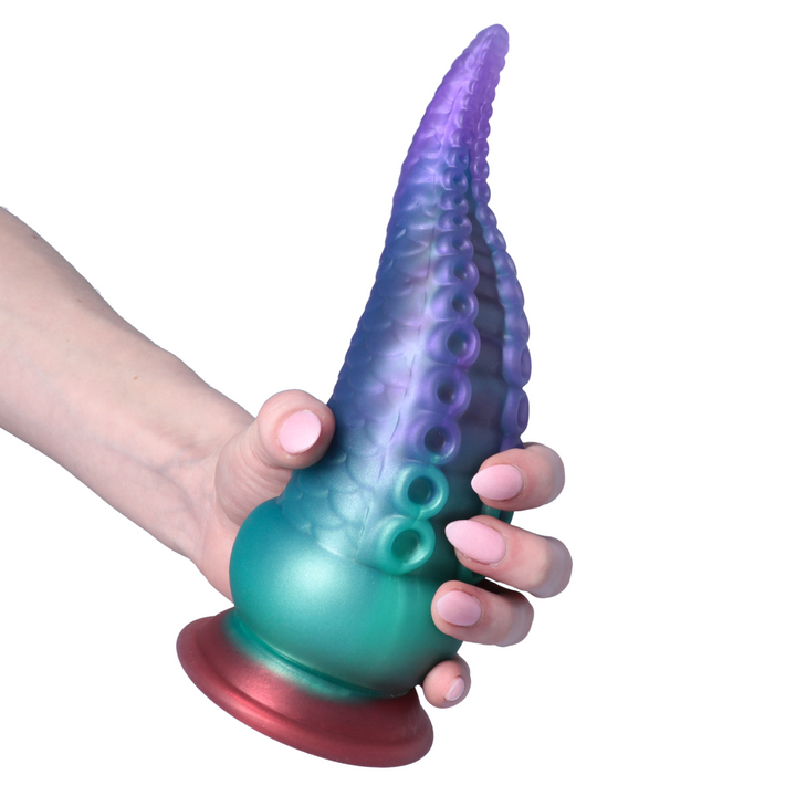 hand with pink painted nails holding tentacle dildo 