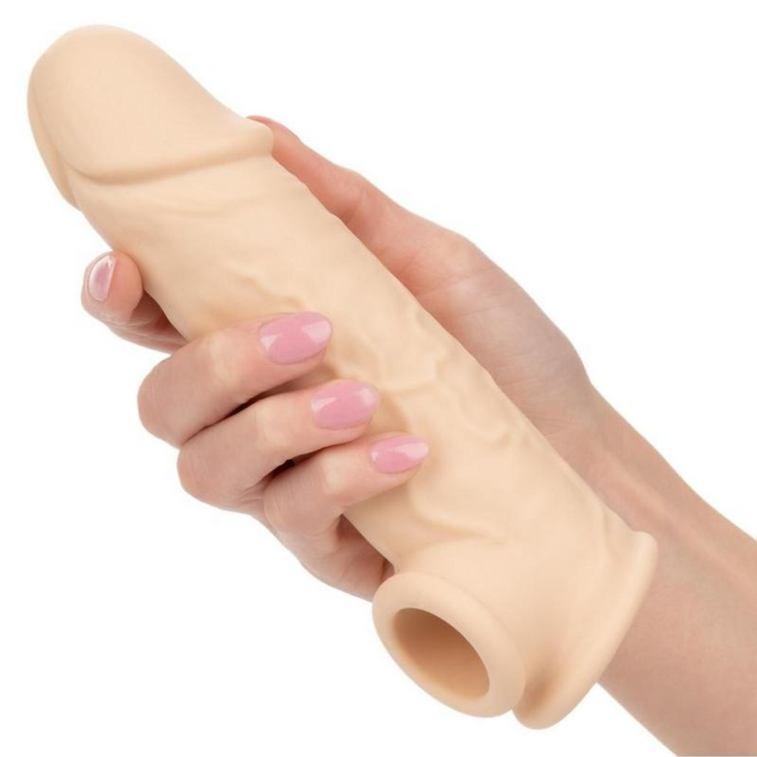 hand holding beige penis extension with veins 