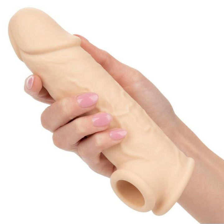hand holding beige penis extension with veins 