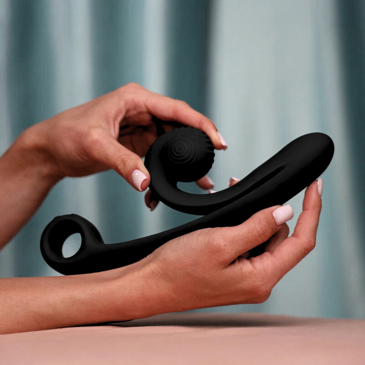 hand holding SVibe Snail CURVE Rechargeable Silicone Vibrator with Clitoral Stimulator green background 