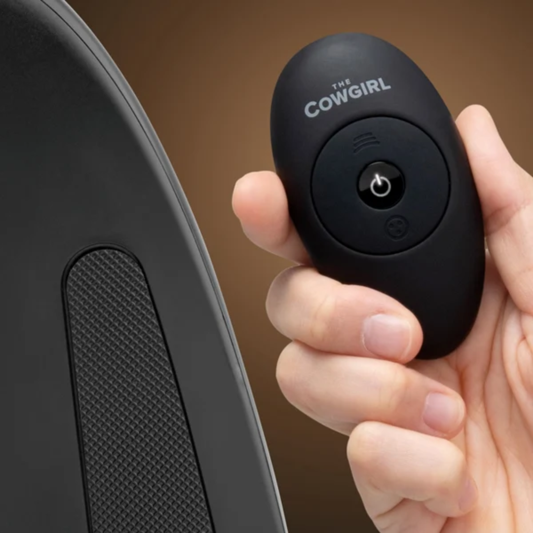 hand holding remote from Cowgirl Saddle Premium Sex Machine