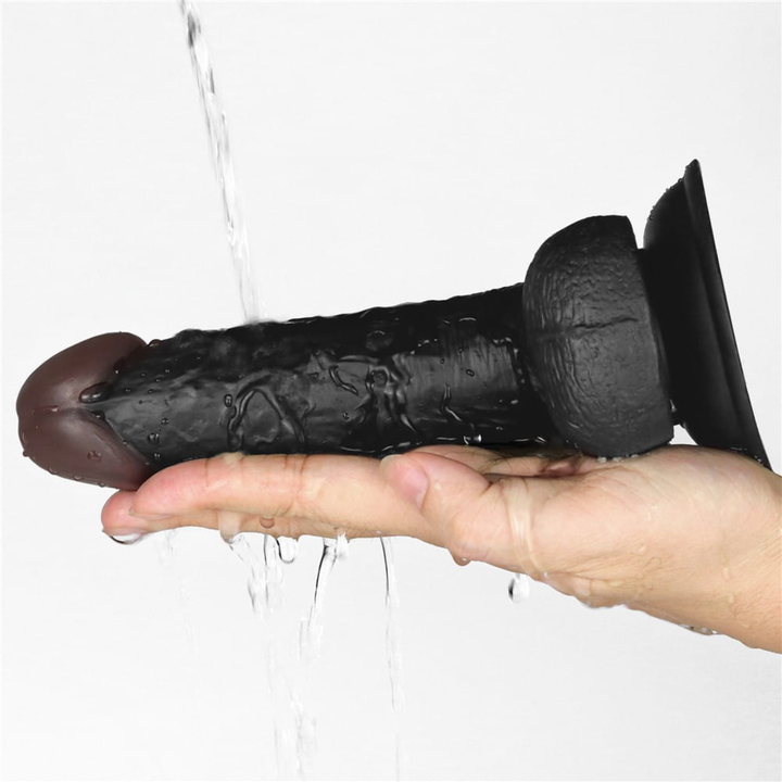 water being poured onto black dildo from Easy Strap on Set 7.0 inches to show waterproof feature 