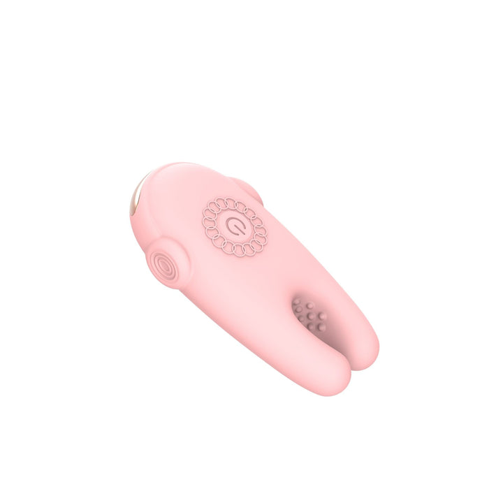 A light pink personal massager with a curved ergonomic design, featuring a circular control dial on the top and textured silicone prongs on one end, shown against a plain white background.