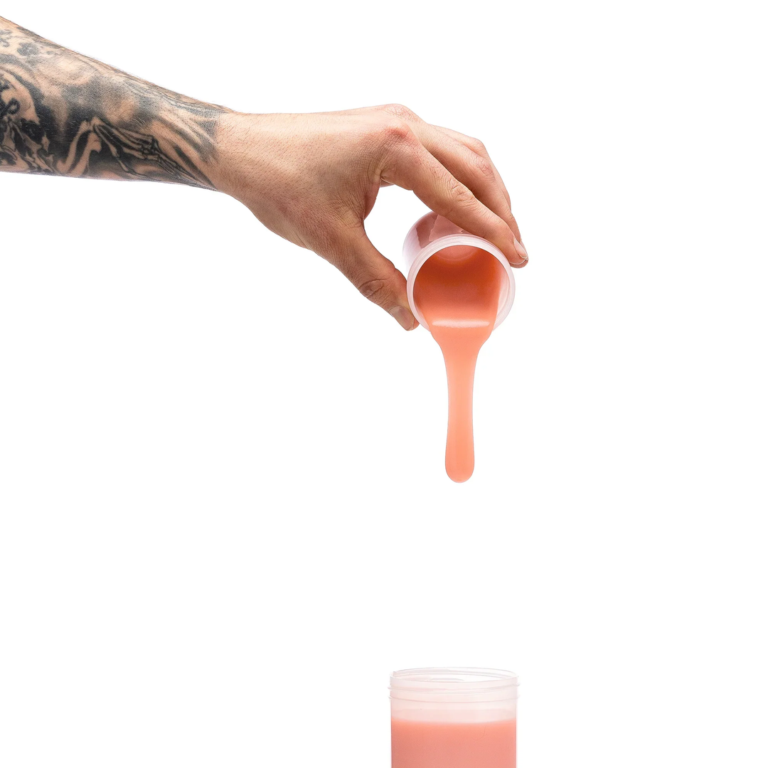hand pouring beige silicone into Clone-A-Willy Silicone Dildo Molding Kit with Vibrator