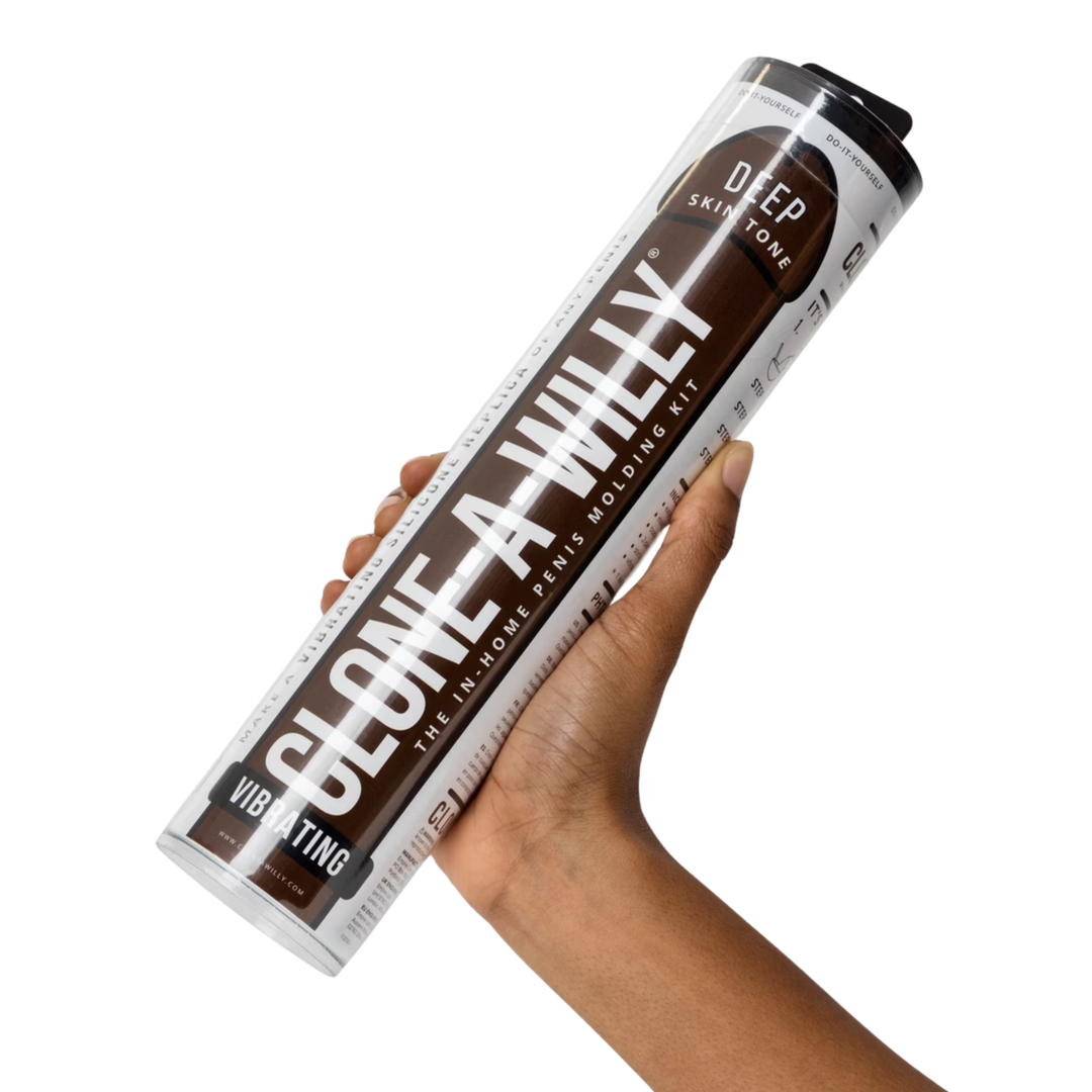 hand holding brown Clone-A-Willy Silicone Dildo Molding Kit with Vibrator in packaging 