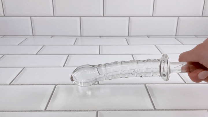 GIF of X-Long Textured Glass Dildo With Handle being banged on table 