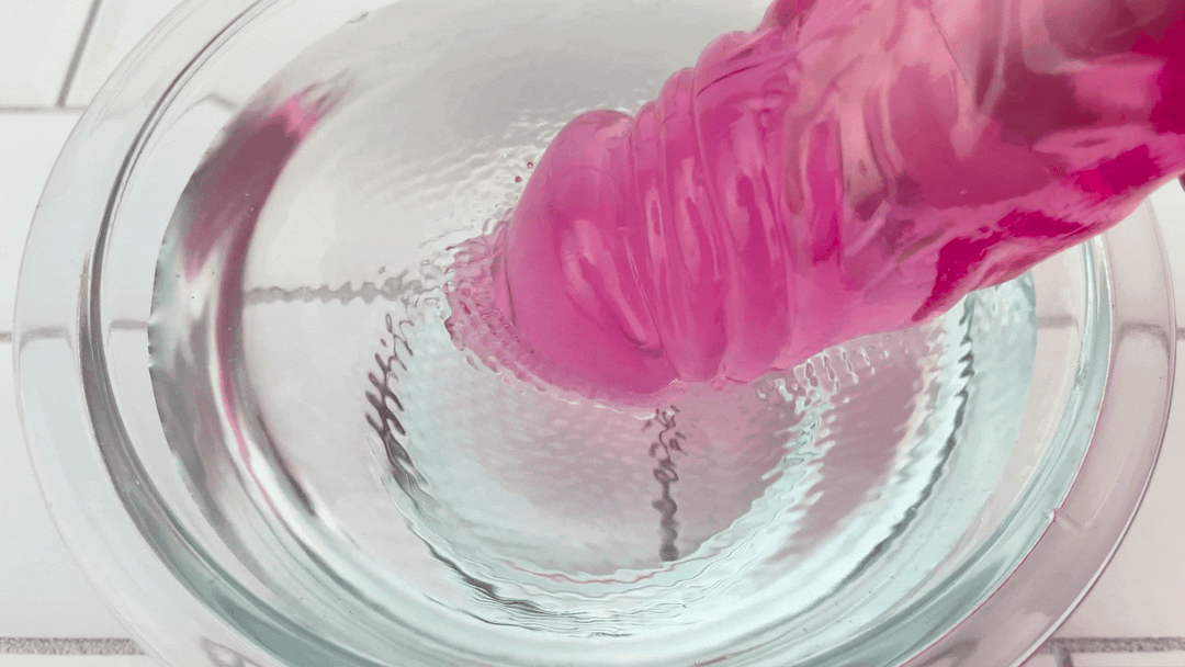 GIF of tip of X-Tra Thick Vibrating Dildo shaft vibrating in bowl of water 