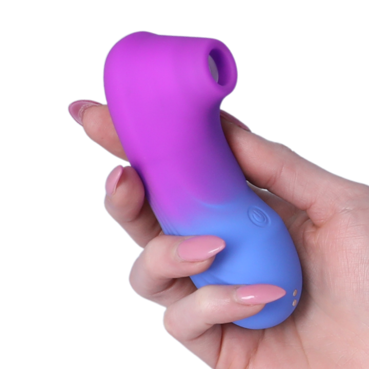 Purple and blue handheld device held in a hand with pink nail polish on a white background
