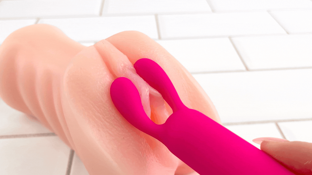 GIF of magenta bullet vibrator pulsating against clit on realistic male masturbator