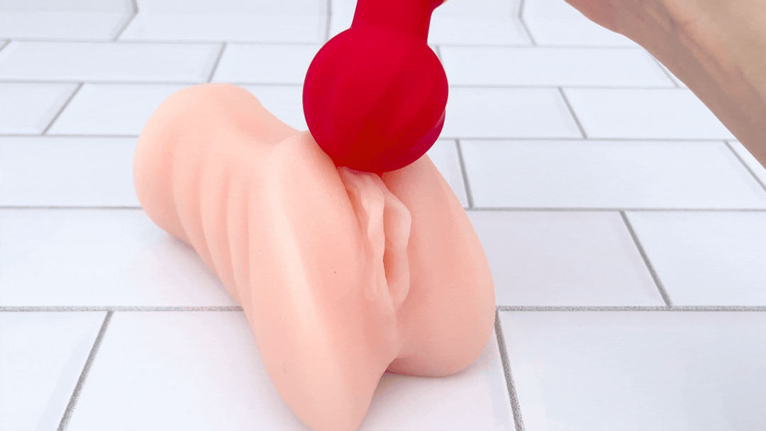 GIF of rounded tip of red wand vibrating on male masturbator