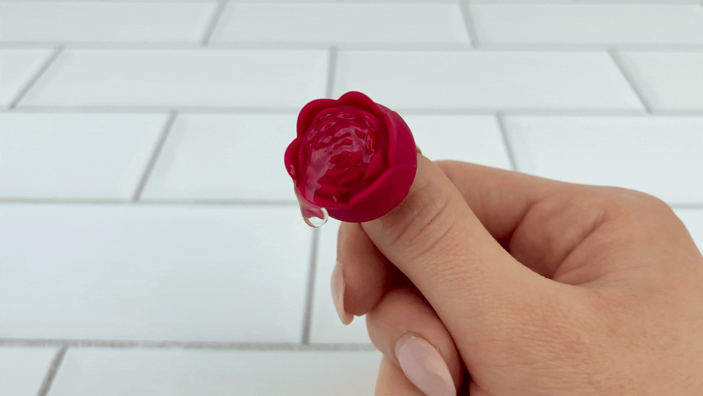GIF of Rose Ring Vibrator on strongest setting with lubricant vibrating on top of it 