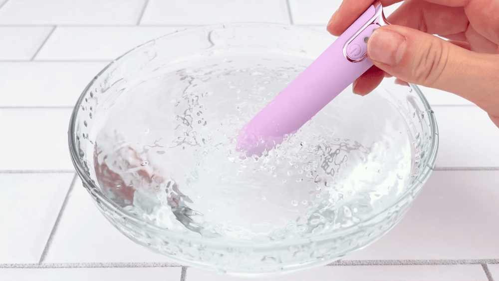 GIF of lavender silicone bullet vibrating in a clear glass bowl of water