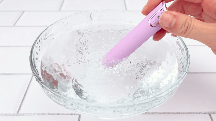 GIF of lavender silicone bullet vibrating in a clear glass bowl of water