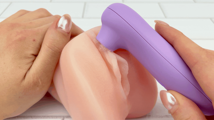 GIF of Lavender Air Pulse Clitoral Stimulator used on clitoris from realistic male masturbator 