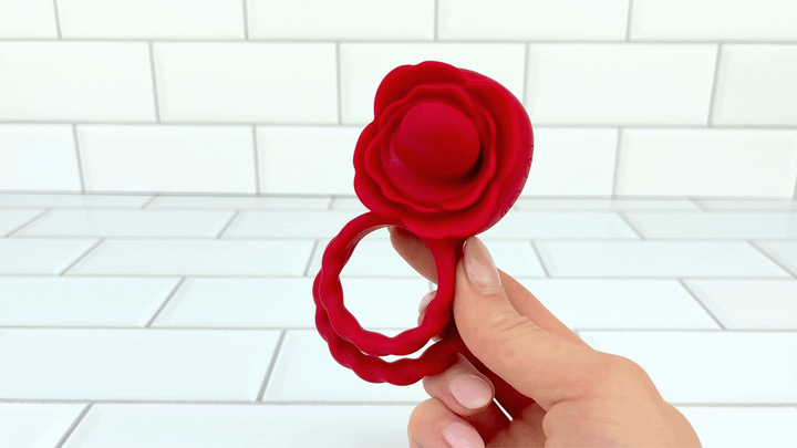 GIF of Twirling Tongue Flower Silicone C-Ring hand holding it 