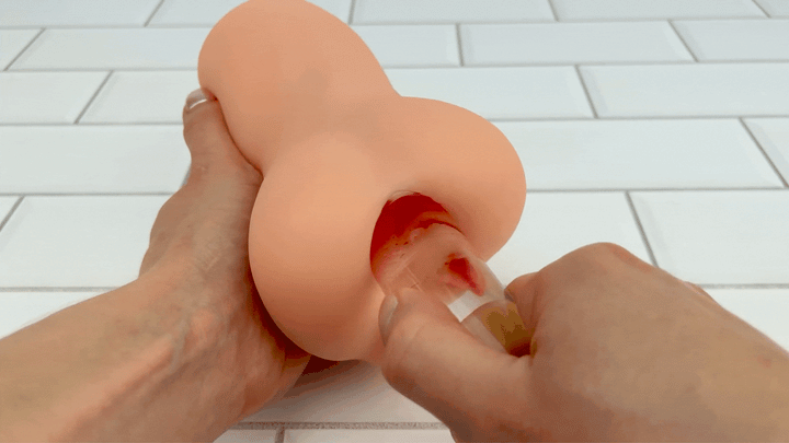 GIF birds eye view of glass dildo being thrusted into anal opening of Pussy and Ass Stroker from TooTimid
