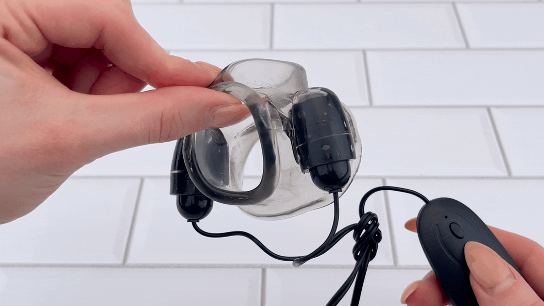 GIF of hand holding Scrotum & Testicle Tension Dual Vibrating Cock Ring at full power 