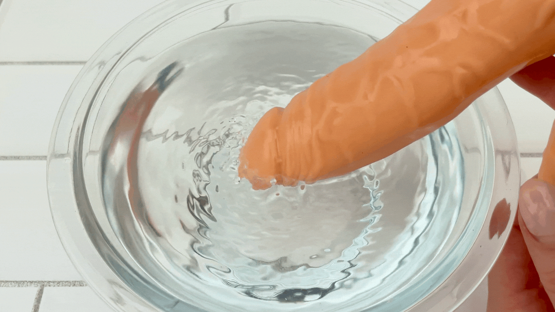 GIF of realistic veined penis shaft from Clit Stimulating Dual Penetration Vibrating Dildo vibrating in bowl of water at highest setting