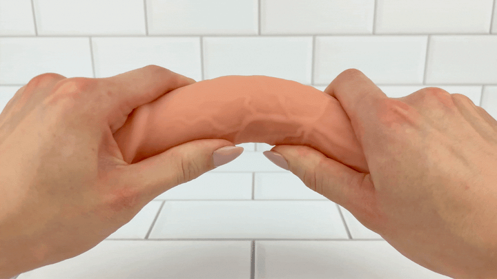 GIF of veined realisitc dildo from Hands-Free Thrusting & Vibrating Silicone Dildo being bent to show flexibility 