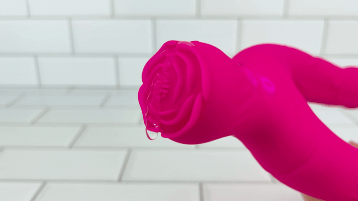 GIF of clitoral nub from hot pink double penetration vibrator  vibrating with lube on it 