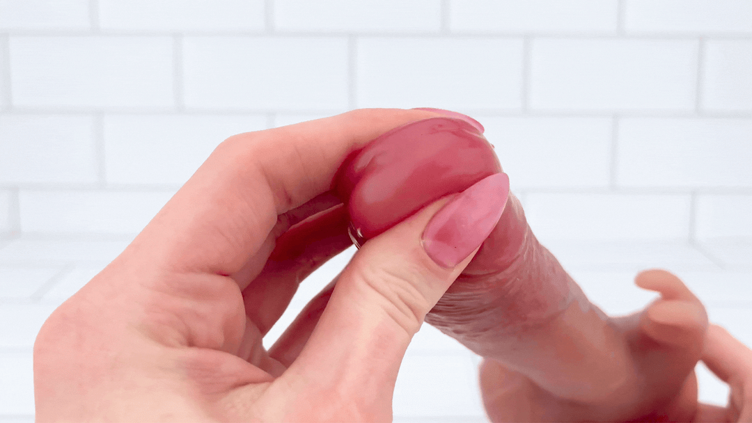 GIF of Heated Thrusting Vibrating Dildo with Rabbit Clit Stimulator tip being squeezed to show soft texture 