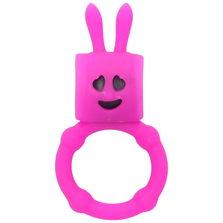 Bird's eye view of hot pink vibrating cock ring with bunny ears and a happy face made of negative space.