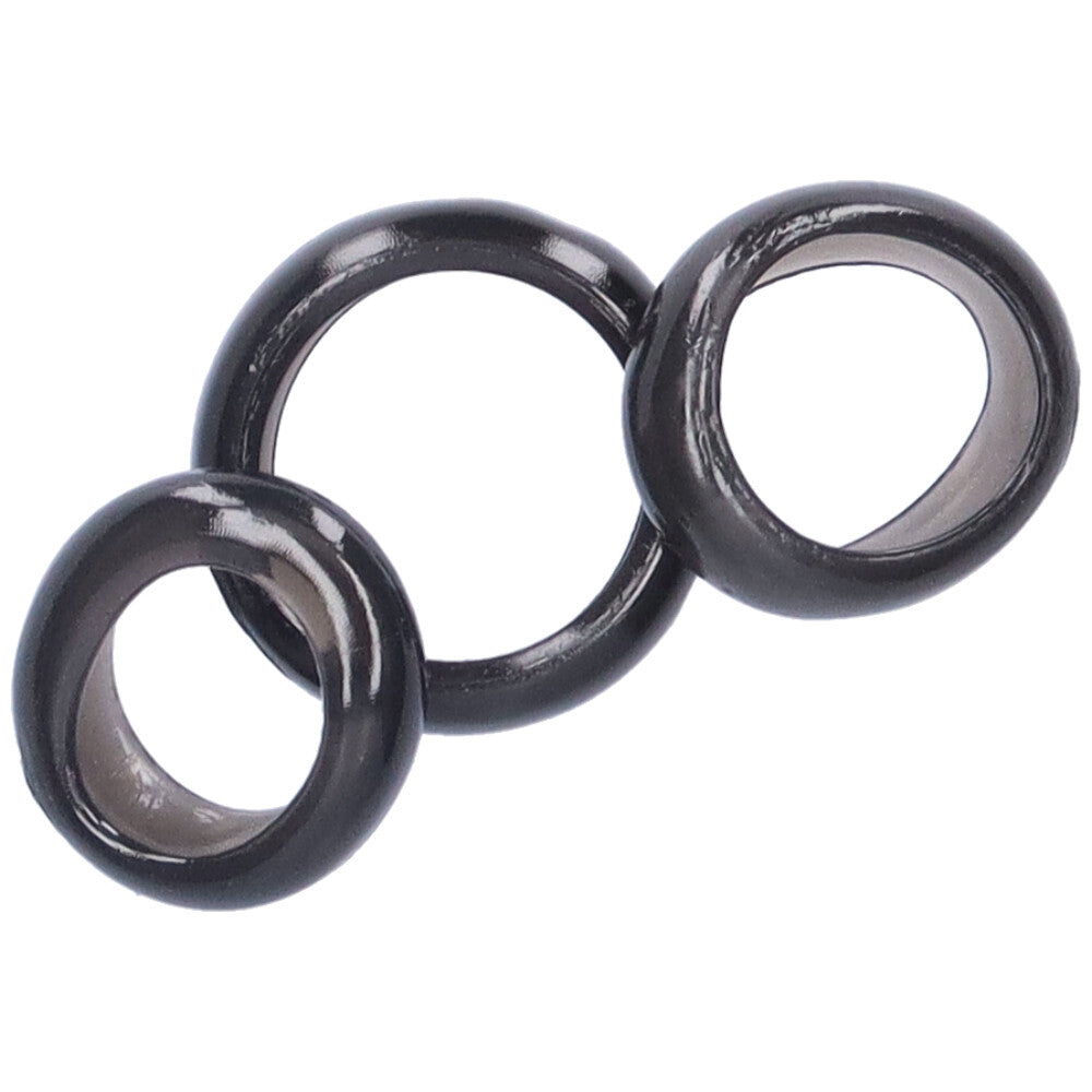 Bird's eye view of 3 black jelly cock rings stacked on top of one another.