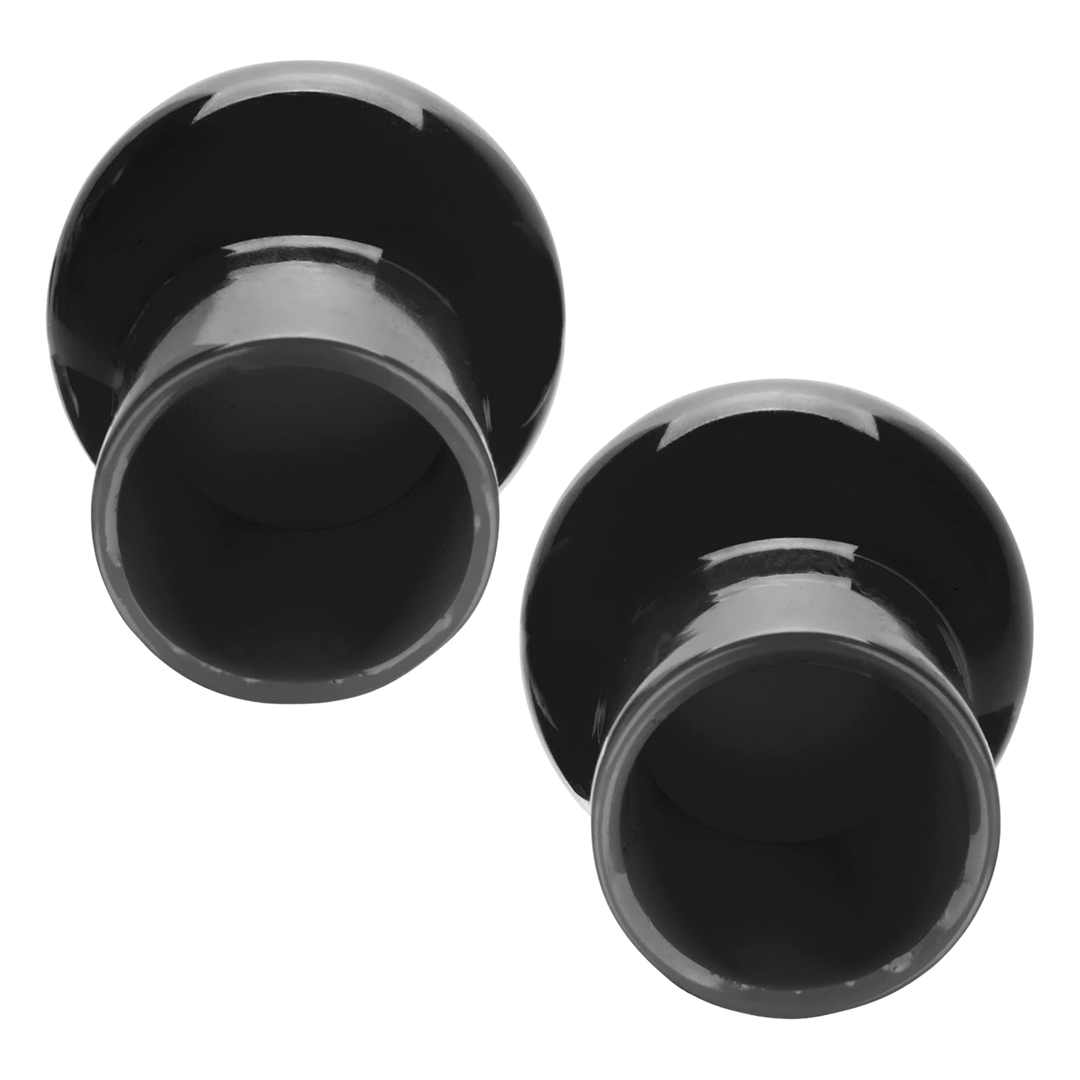 Front view of two black plastic nipple suckers on a white background