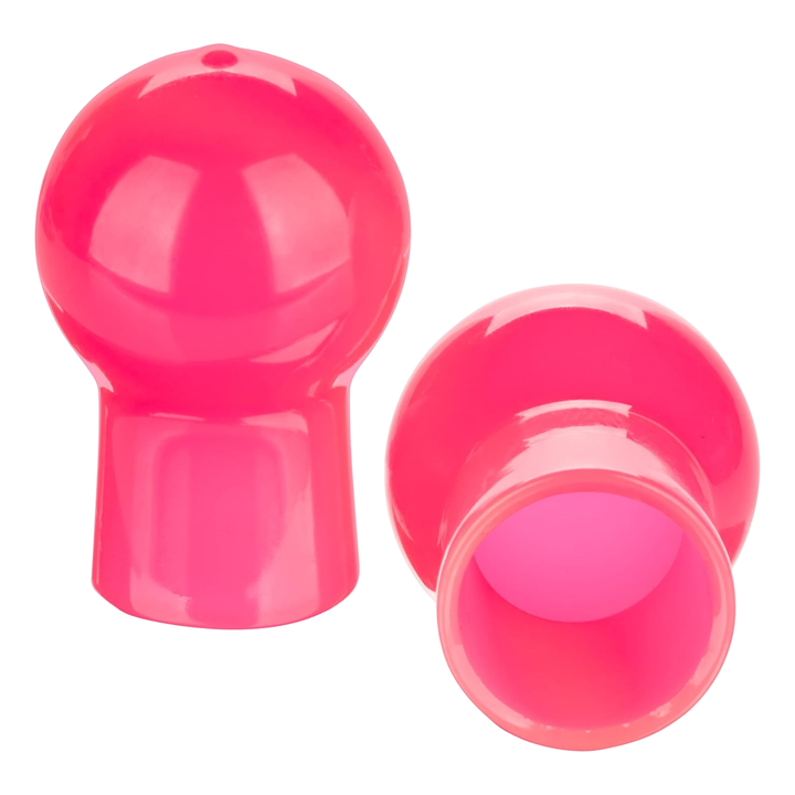 Two pink plastic nipple suckers on a white background