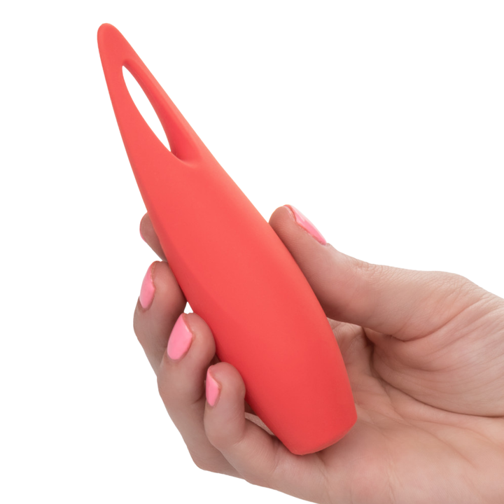 Hand holding a red silicone clit encasing vibe on a white background