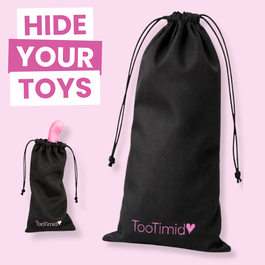 Black drawstring pouches with the TooTimid logo, shown on a light pink background with promotional text reading 'HIDE YOUR TOYS'. One pouch is large and one is small, both with black cords and pink logo details.
